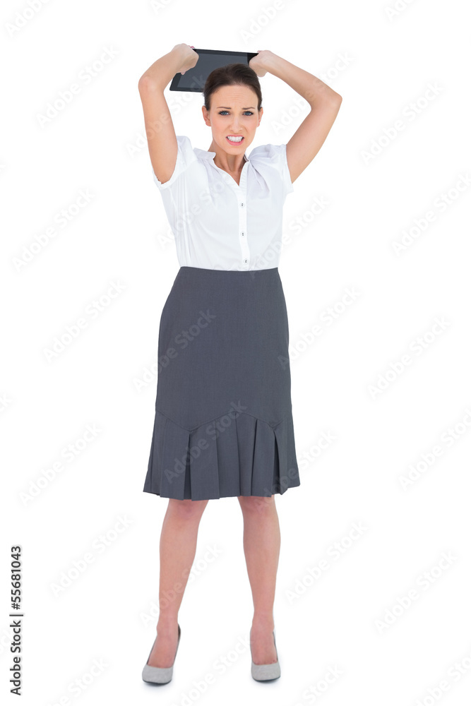 Fototapeta premium Furious businesswoman throwing her tablet pc