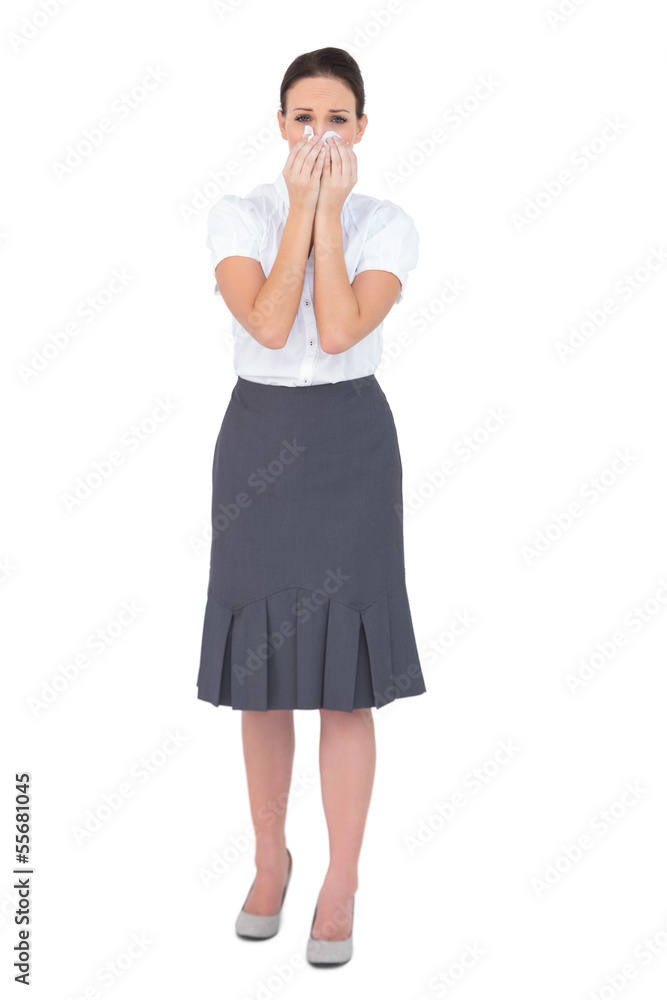 Fototapeta premium Upset businesswoman blowing her nose