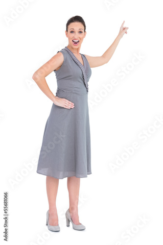 Cheerful gorgeous woman in classy dress indicating direction