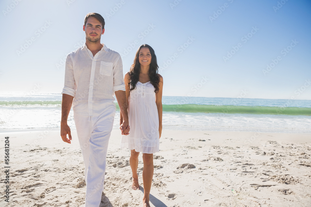Beautiful couple holding hands and walking towards camera Beautiful couple holding hands and walking towards camera