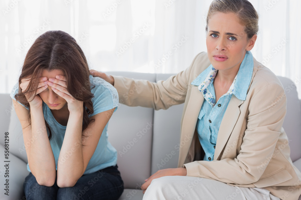 Worried woman being comforted by her understanding therapist Worried woman being comforted by her understanding therapist
