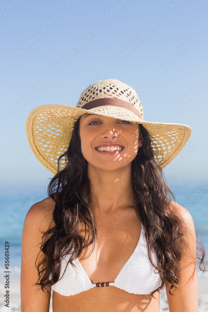 Attractive dark haired woman wearing straw hat posing