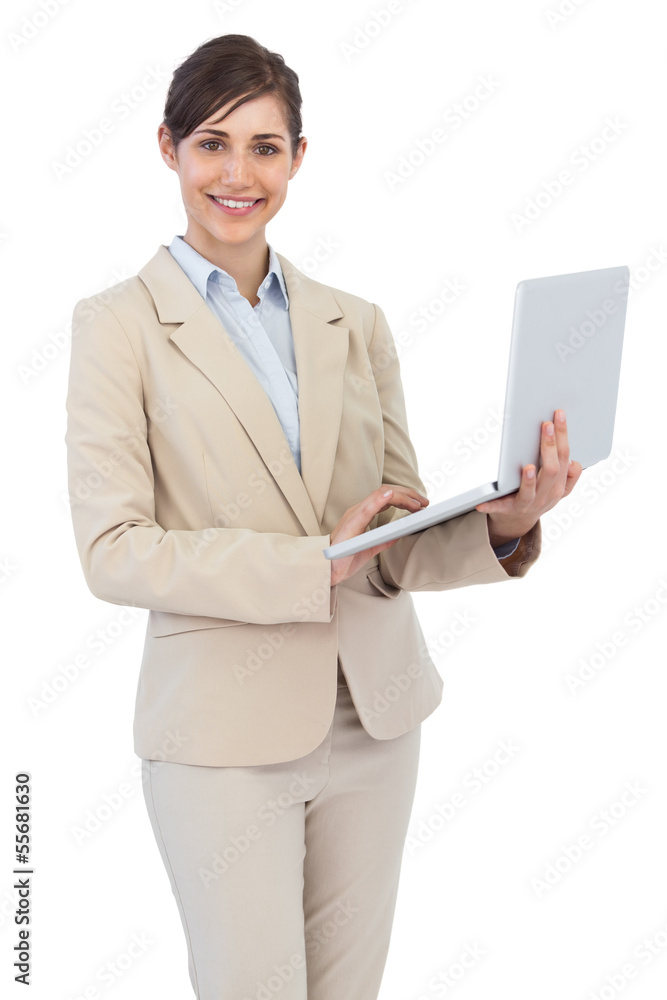 Smiling young businesswoman holding laptop