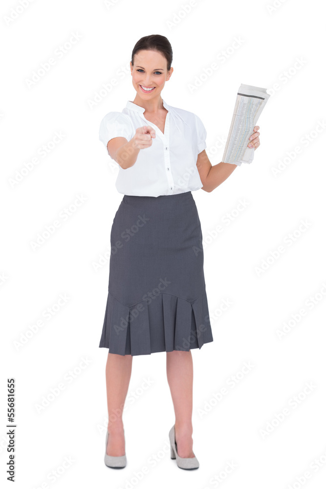 Stylish businesswoman pointing while holding newspaper Stylish businesswoman pointing while holding newspaper