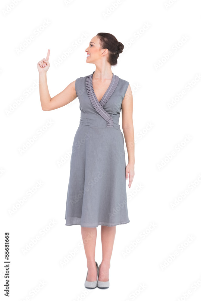 Content elegant woman in classy dress pointing finger up Content elegant woman in classy dress pointing finger up