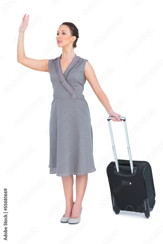 Gorgeous woman carrying her suitcase calling taxi Gorgeous woman carrying her suitcase calling taxi