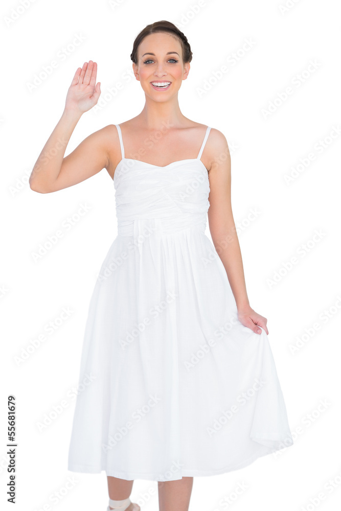 Smiling beautiful young model in white dress waving Smiling beautiful young model in white dress waving
