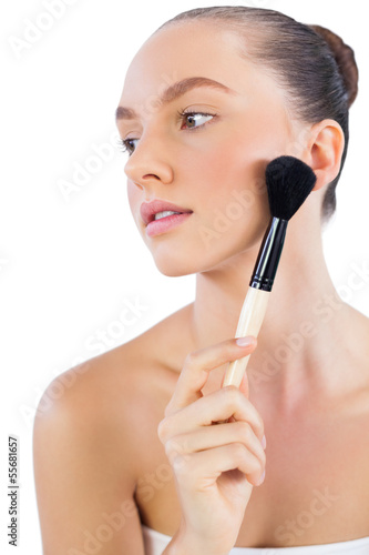 Model touching her face with powder brush