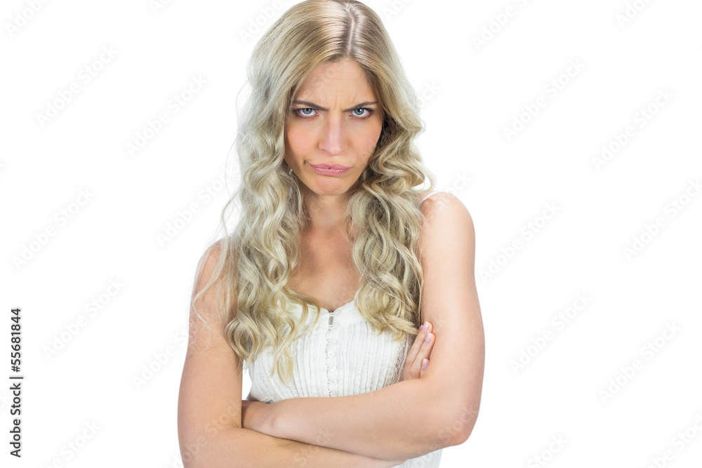Frowning seductive model in white dress posing crossing arms Frowning seductive model in white dress posing crossing arms