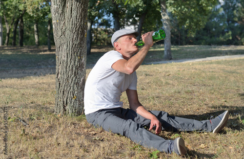 Alcoholic sitting drinking in a park