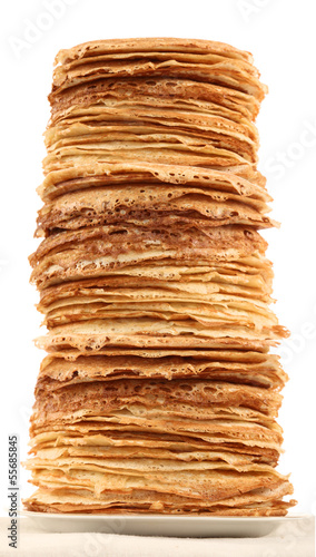 Very high pile of pancakes on plate