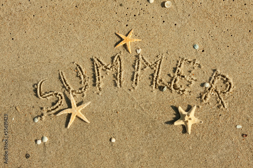 Word summer written by in the sand