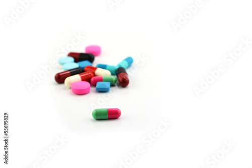 Colorful medical pills and capsules on white background.