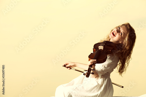 The blonde girl with a violin outdoor