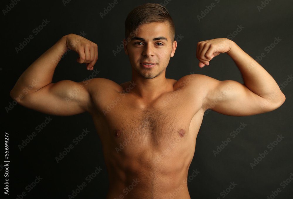 Fototapeta premium Portrait of muscle man on grey background