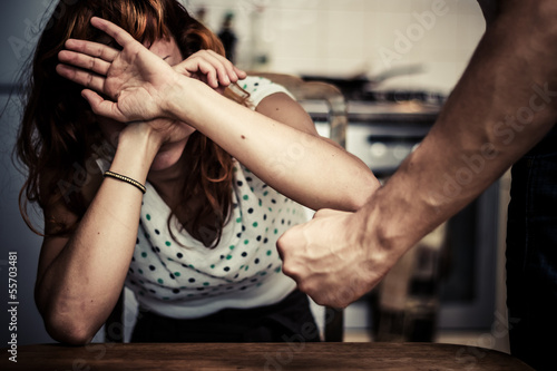 Woman covering her face in fear of domestic violence photo