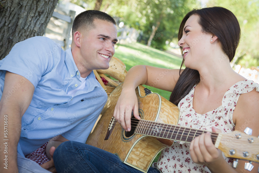 Fototapeta premium Mixed Race Couple at the Park Playing Guitar and Singing