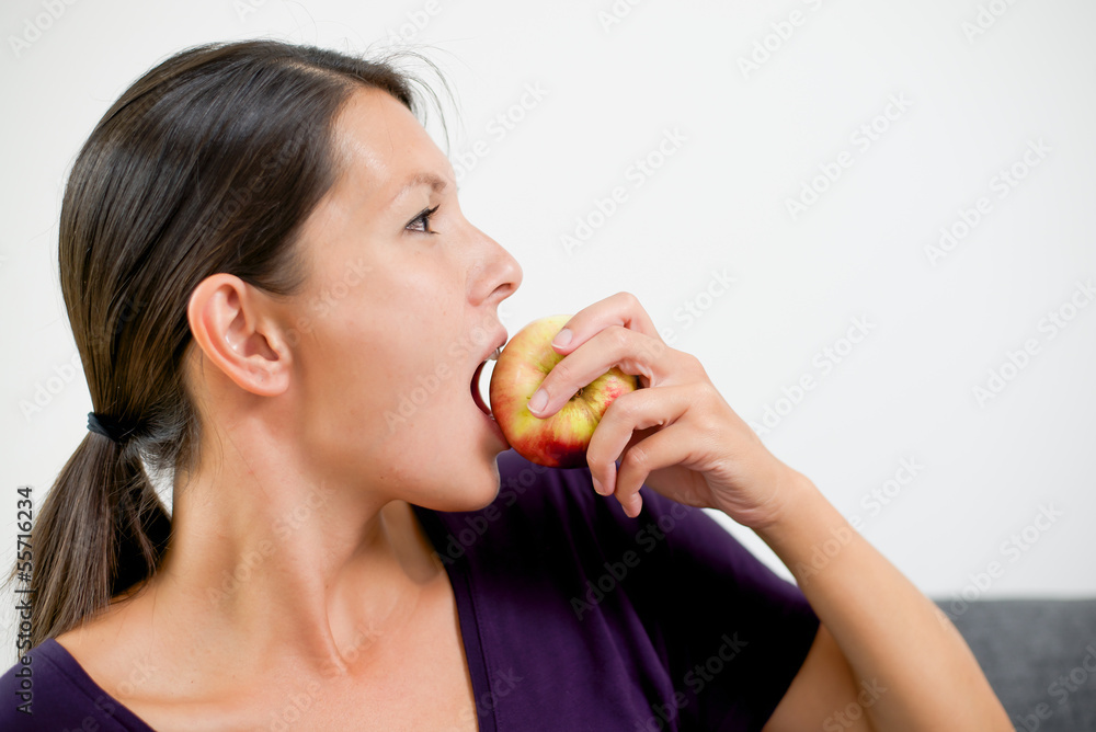 Attractive woman biting a fresh red apple Attractive woman biting a fresh red apple
