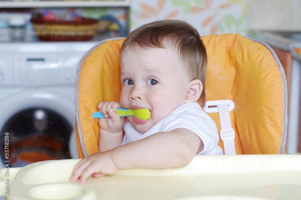 lovely baby age of 11 months with spoon on kitchen lovely baby age of 11 months with spoon on kitchen