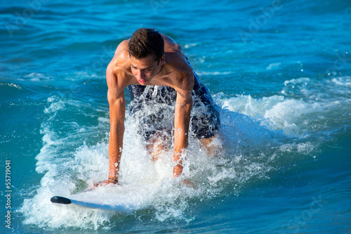Boy surfer surfing waves on the beach © lunamarina