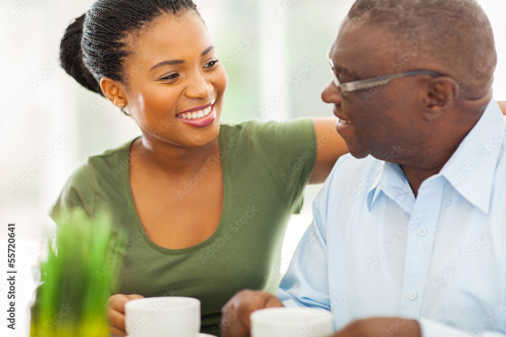 elderly african american man enjoying coffee with his granddaugh elderly african american man enjoying coffee with his granddaugh