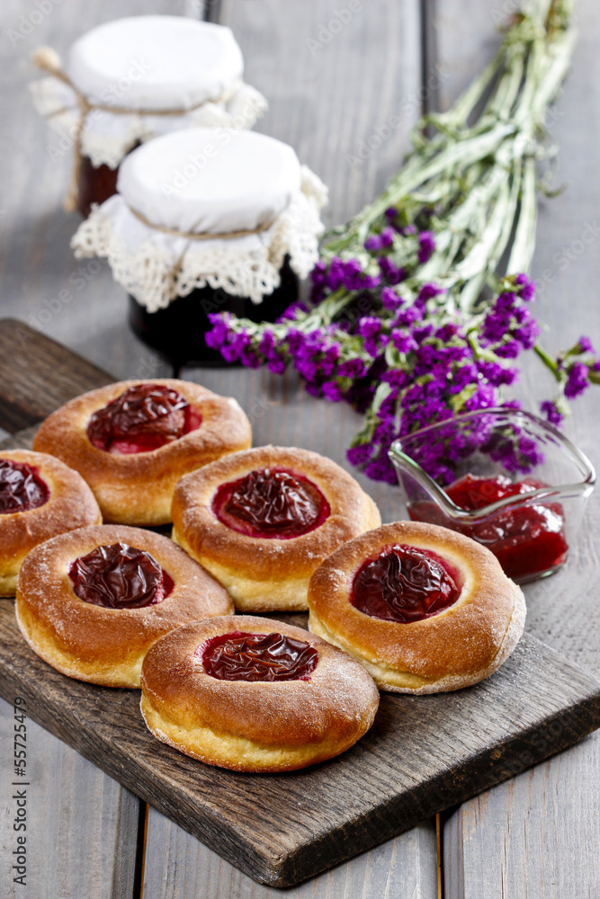 Round buns with plum on wooden table