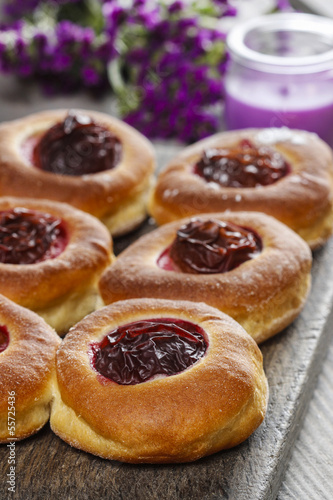 Round buns with plum on wooden table