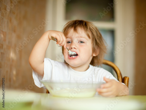 child eats with spoon