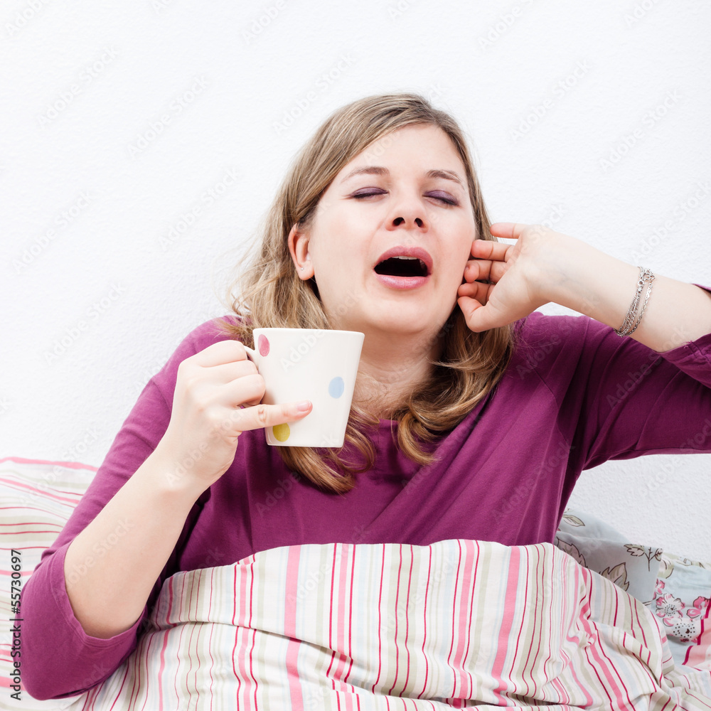 Woman with cup of coffee yawning Woman with cup of coffee yawning