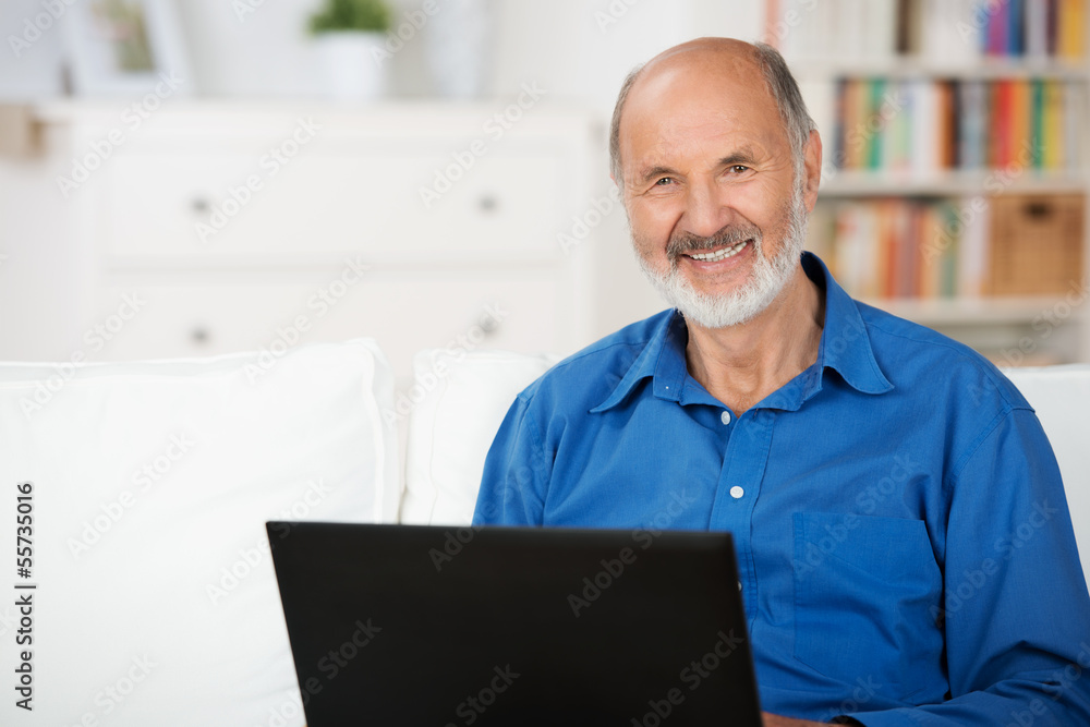 Fototapeta premium lächelnder senior mit laptop zu hause