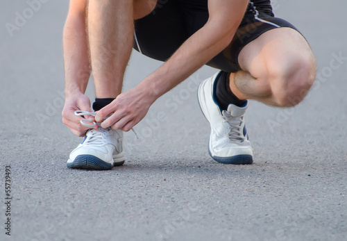 Man tying his sport shoes © M-Production