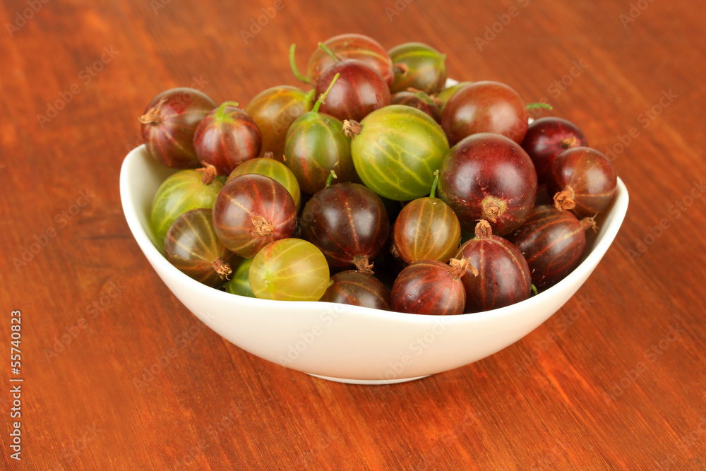 Obraz premium Fresh gooseberries in bowl on table close-up