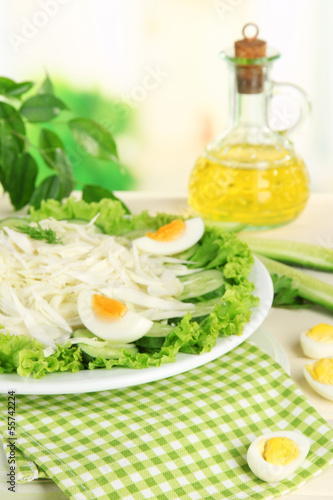 Delicious salad with eggs, cabbage and cucumbers on wooden