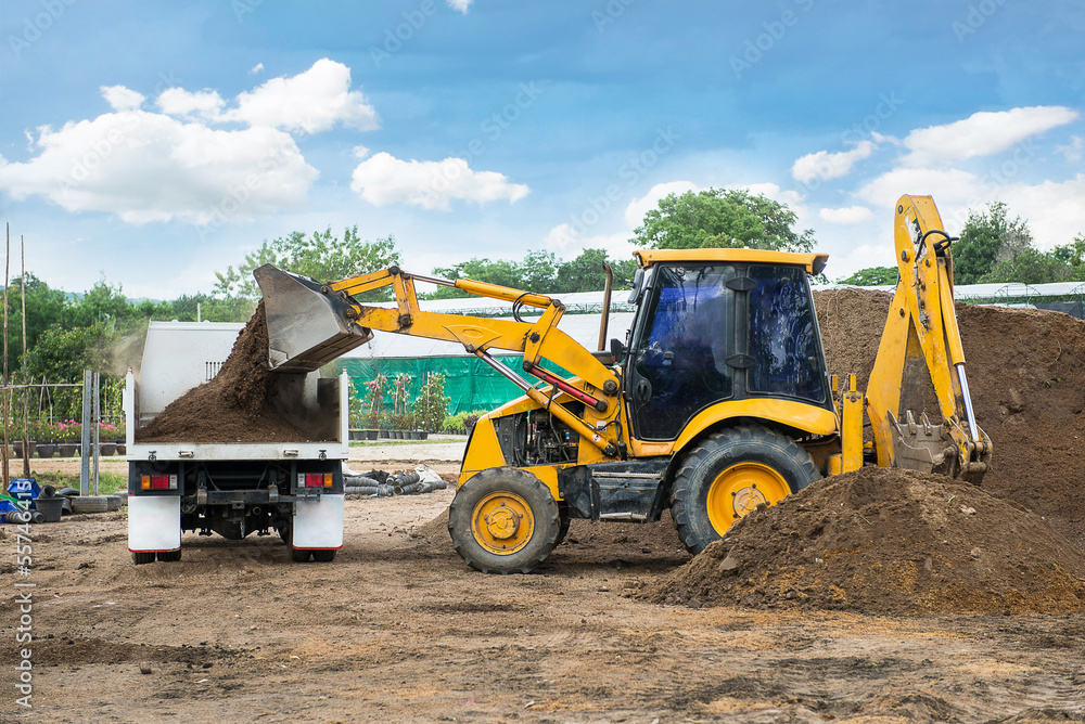 Tractor with front and loader bucket and backhoe with truck