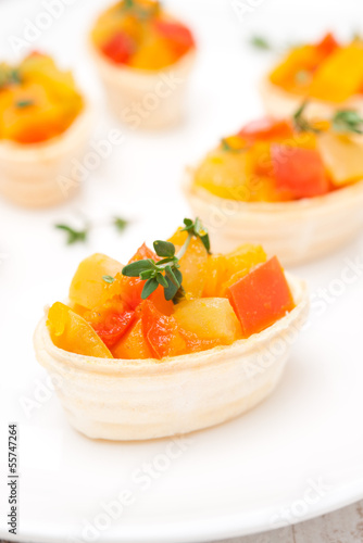 roasted vegetables with thyme in tartlets on the plate, close-up