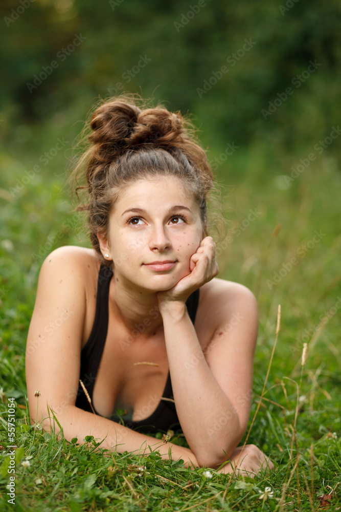 young female lying down on grass young female lying down on grass