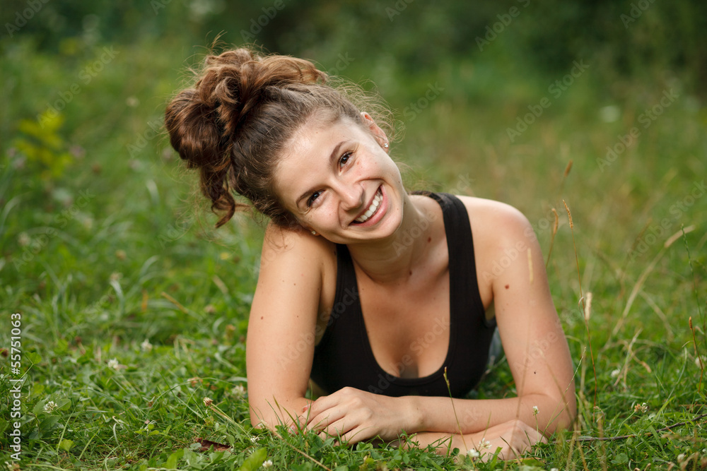 young female lying down on grass young female lying down on grass