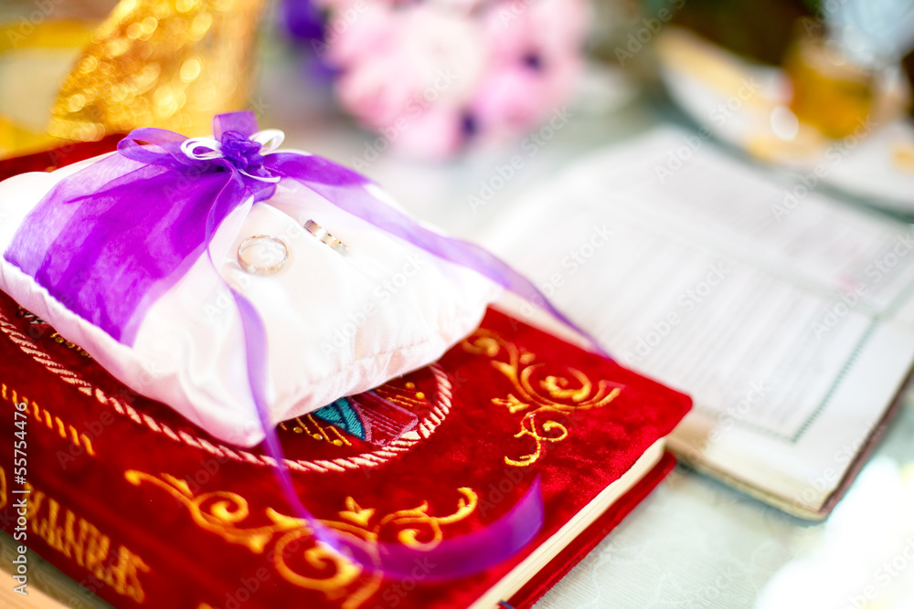 Wedding rings on a cushion with holy bible underneath Wedding rings on a cushion with holy bible underneath