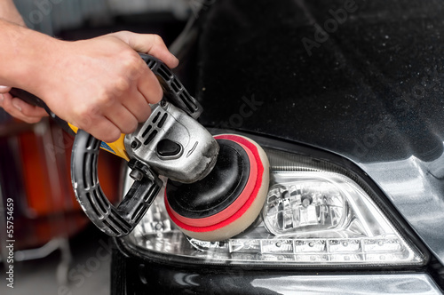 Car headlights cleaning with power buffer machine at car service photo