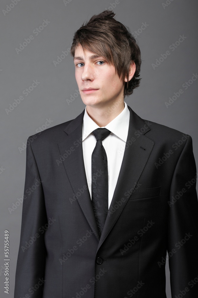 young businessman black suit casual tie on gray background young businessman black suit casual tie on gray background