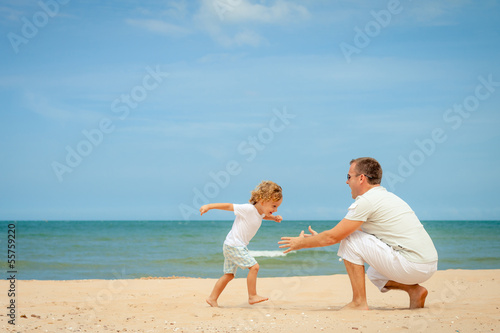 father and son playing at the beach in the day time