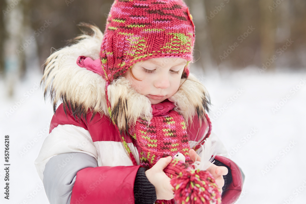 Little girl stands in winter park