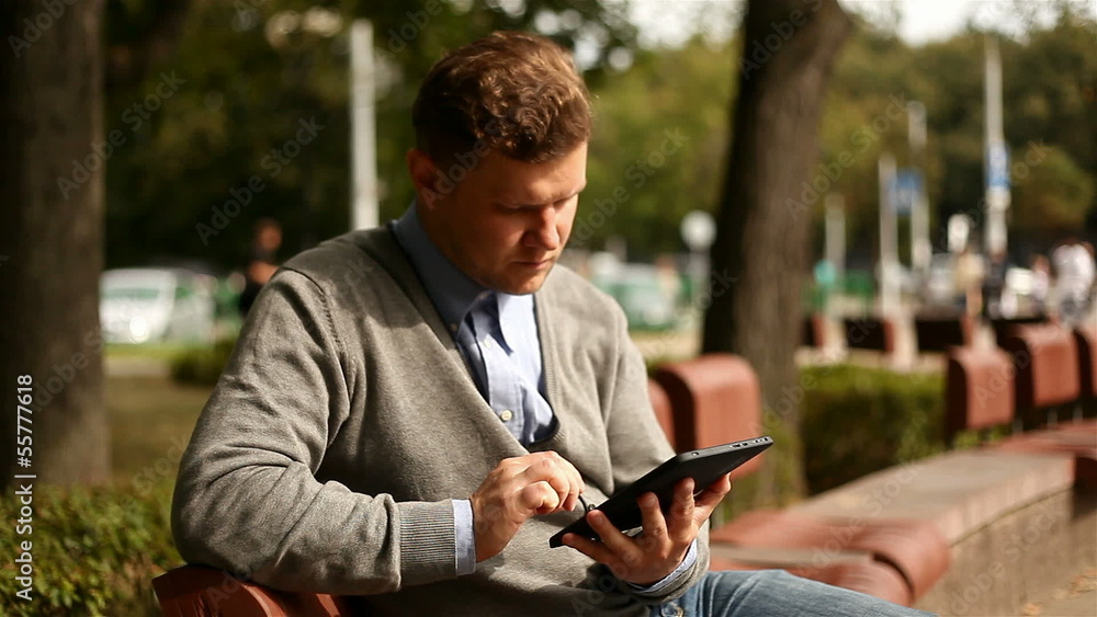 Young businessman working on tablet computer in city park, 1080p Young businessman working on tablet computer in city park, 1080p