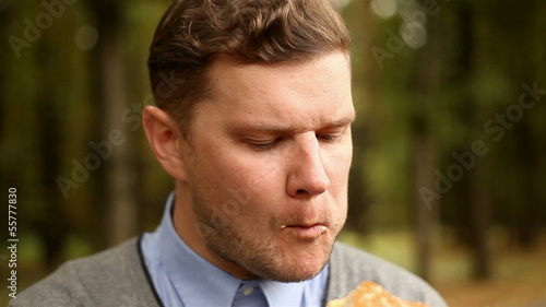 young businessman eating a hamburger