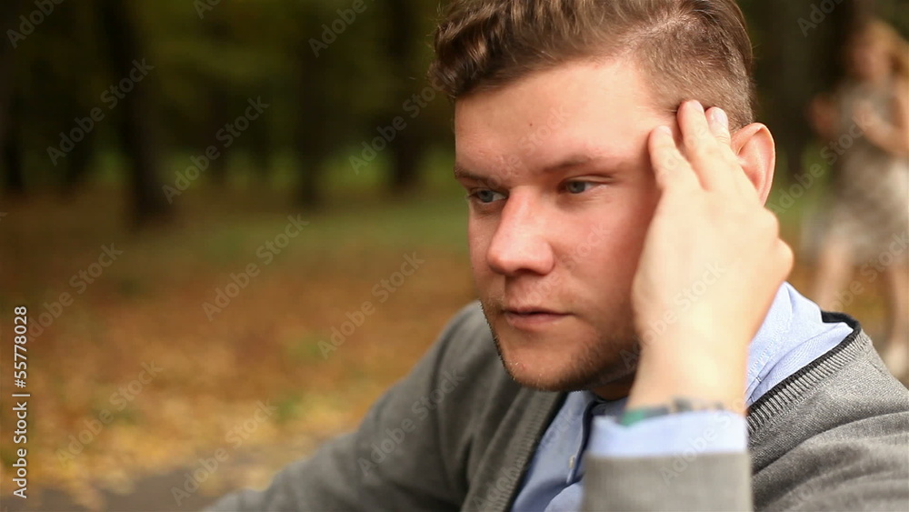 Depressed, sad young businessman sitting in the park, 1080p Depressed, sad young businessman sitting in the park, 1080p