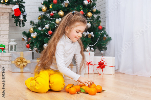 Happy little girl with mandarins