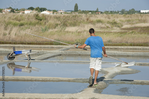 Salt pans France worker skimming salt