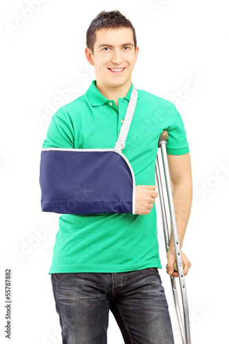 Smiling male with broken arm and crutch