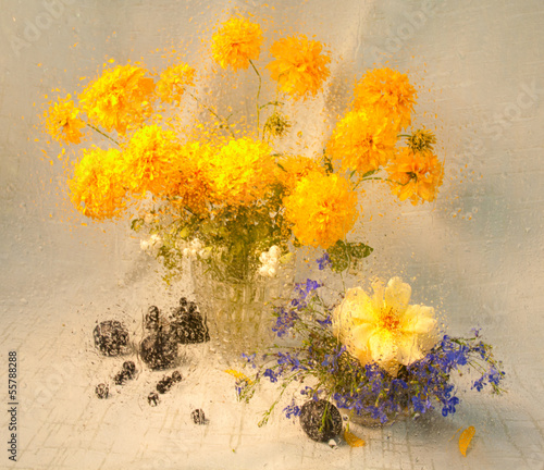 still life of yellow flowers through wet glass on a rain