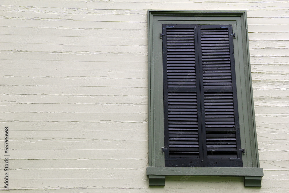 Long shuttered window in light colored wall